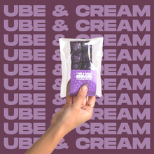 Load image into Gallery viewer, The Ube & Cream Brownie being held up by model's hand.