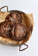 Load image into Gallery viewer, Three Salted Toffee Chocolate Cookies placed in a pan lined with parchment paper.
