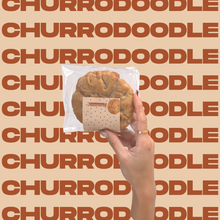 Load image into Gallery viewer, The Churrodoodle being held up by model&#39;s hand,
