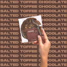 Load image into Gallery viewer, The Salted Toffee Chocolate Cookie being held up by model&#39;s hand.
