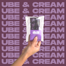 Load image into Gallery viewer, The Ube &amp; Cream Brownie being held up by model&#39;s hand.
