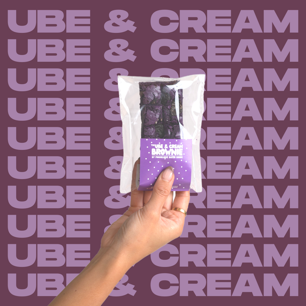 The Ube & Cream Brownie being held up by model's hand.